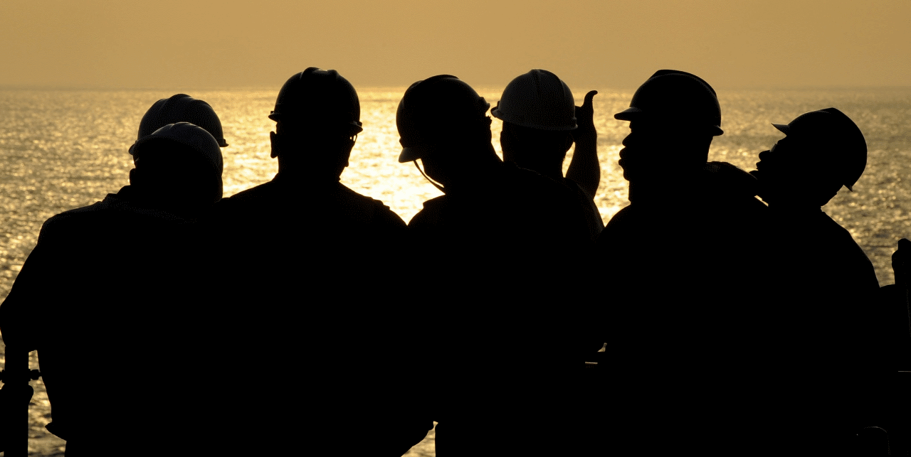 Men in hardhats infront of sea